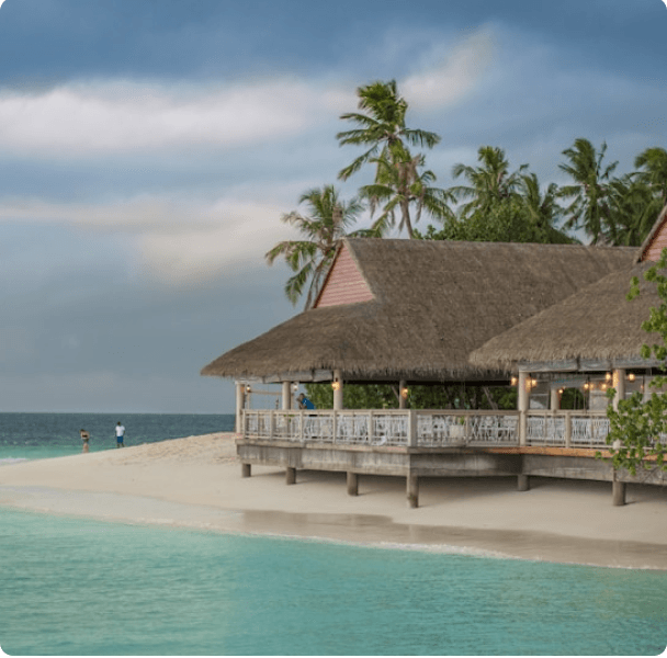 A tropical beachfront bungalow beside turquoise water